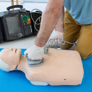 Paramedic practicing resuscitation on dummy in clinic