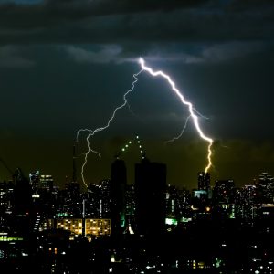 Thunder storm lighting bolt on the horizontal sky and city scape